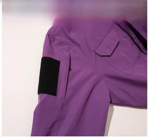 Detail view of purple hooded jacket sleeve showing hidden zipper pocket and velcro strap