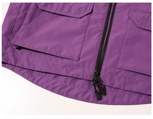 Detail of purple hooded outdoor jacket featuring cargo pockets and dual black zipper closure