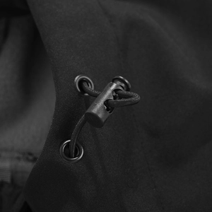 Detail van het verstelbare trekkoord en de koordstopper op het zwarte softshell jack voor heren