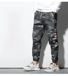 Détail d'un pantalon cargo camouflage gris avec poches latérales et chevilles resserrées