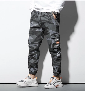 Détail du pantalon cargo camouflage gris avec grandes poches à rabat et texte graphique