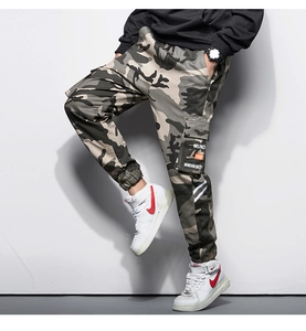 Détail des poches cargo et motif camouflage sur le pantalon de jogging tactique