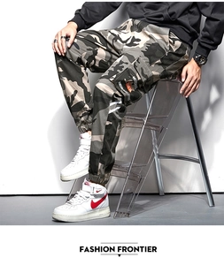 Détail du pantalon cargo camouflage avec grandes poches latérales et étiquettes tissées