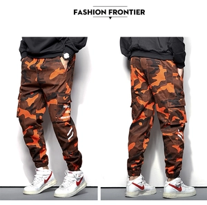 Détails du pantalon cargo camouflage orange avec grandes poches et chevilles élastiquées