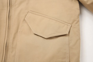 Detailopname van khaki katoenen jack met metalen rits en zak met een functionele klep