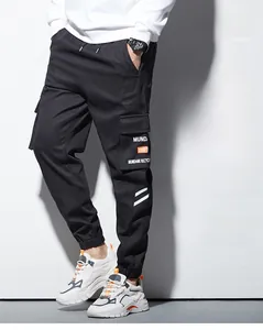 Détail du pantalon cargo avec poches latérales à rabat et logo lettrage blanc