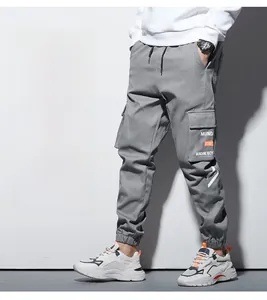 Détail de la poche latérale du pantalon cargo avec marquage MUNDANE et design pratique