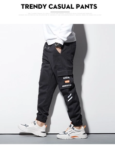 Détail du pantalon cargo noir avec taille élastique à cordon et poche latérale à rabat