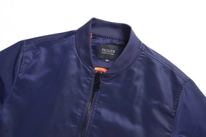 Detail of navy bomber jacket featuring a standing collar with vibrant orange lining