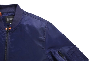 Detail of navy bomber jacket with ribbed collar and MA-1 style zipper pocket on sleeve