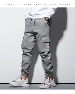 Détail du pantalon cargo gris avec poches latérales à rabat et chevilles côtelées