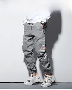 Détail du pantalon cargo gris avec poches latérales à rabat et imprimé de lettres