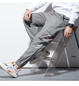 Détail du pantalon cargo gris avec taille à cordon et poche latérale emblématique
