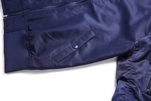 Detailed view of navy blue flight jacket featuring metal zipper and snap button pockets
