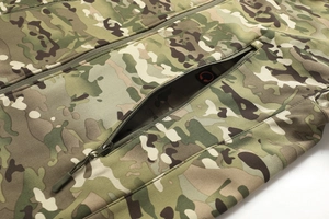Detailed close-up of tactical camo jacket chest pocket with waterproof zipper and media port