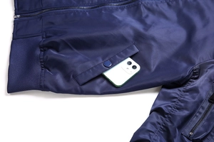Detail of navy bomber jacket side pocket with metal snap button and smartphone for scale