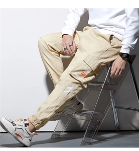 Détail du pantalon cargo kaki avec de grandes poches latérales et imprimé MUNDANE