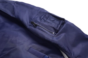 Detail of the navy blue bomber jacket sleeve featuring a zipper pocket and smooth fabric