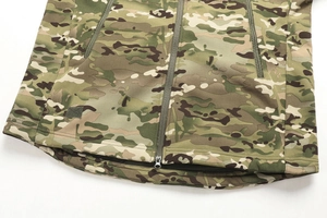 Detail of multicam tactical jacket featuring durable fabric and metallic front zipper closure