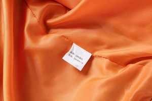 Detailed close-up of the orange lining and care label on this baseball jacket