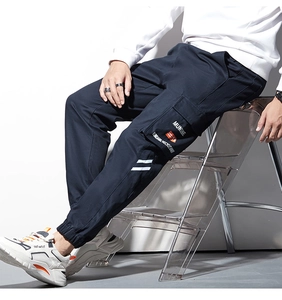Vue détaillée du pantalon cargo avec poches à rabat et imprimé blanc sur tissu bleu marine