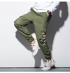 Détail du pantalon cargo vert olive avec de grandes poches latérales et taille élastique