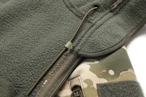 Detail of olive green tactical fleece jacket with multicam pattern and zipper