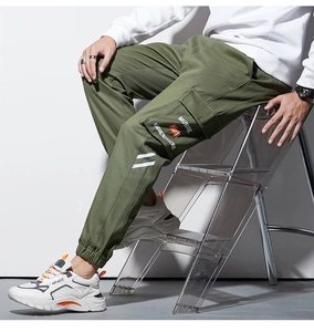 Gros plan sur le pantalon cargo vert militaire avec poche à rabat et bas élastiques