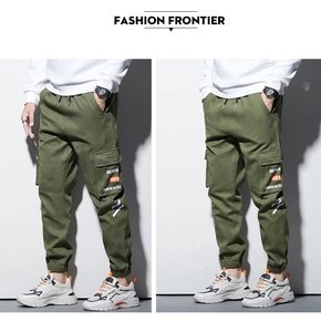 Détail du pantalon cargo avec grandes poches à rabat, imprimé et poignets élastiques