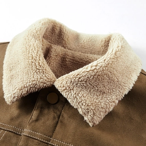 Dettaglio della giacca in scamosciato marrone con colletto in shearling beige e bottone