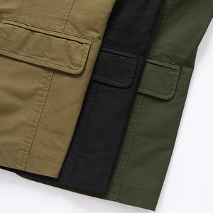 Dettaglio del tessuto in twill di cotone e tasche cargo in kaki, nero e verde scuro