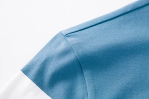 Detailaufnahme der blau-weißen Polo-Ärmelnähte und die feine Strickstruktur des Stoffes