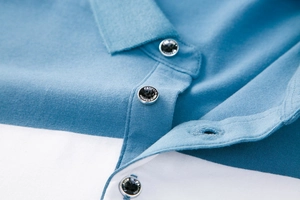 Detail eines blau-weiß gestreiften Poloshirts mit gravierten Knöpfen und Strickstruktur