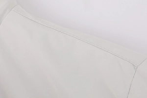 Détail des coutures d'épaule et texture du tissu tissé sur un manteau d'hiver beige pour hommes