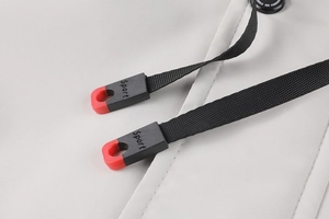 Détail du cordon de serrage de la veste d'hiver avec embout sport noir et rouge