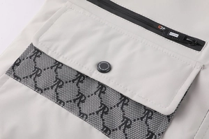 Détail de la veste d'hiver avec fermeture éclair, bouton logo et texture du tissu