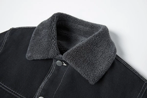 Detail van de fleece kraag en contraststiksels op zware zwarte katoenen jas voor heren