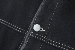 Detail van zwarte denim jas met contraststiksels en warme fleece voering