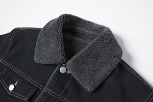 Dettaglio del colletto della giacca di jeans nera con fodera in pile grigio scuro e bottoni in metallo