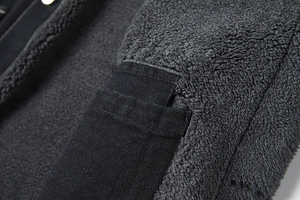 Detail van dikke grijze sherpa voering en duurzame zwarte twill katoenen jasstof van dichtbij