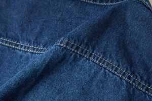 Dettaglio macro del tessuto denim blu scuro con doppie cuciture rinforzate