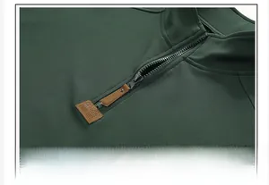 Detalle de sudadera verde militar con textura de panal y cremallera con tirador de cuero