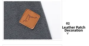 Detailansicht des Leder-Patches mit Berg-Logo auf einem dunkelgrauen Fleece-Kapuzenpulli