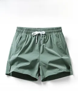Detail of sage green athletic shorts featuring elastic waistband, white drawstring, and side pockets