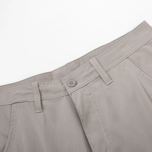 Close-up of khaki cargo pants waist with button detail and reinforced stitching
