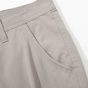 Detailed close-up of waistline, belt loops and side pockets on light grey cargo pants