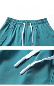 Detail view of elastic waistband with white drawstring on teal fitness shorts