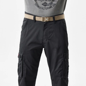 Detail of black cargo pants with side flap pockets and a khaki canvas utility belt