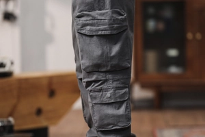 Detail shot of cargo pants showing deep grey fabric texture and side flap pocket