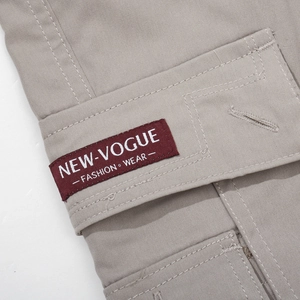 Close-up of cargo pants pocket with red fabric label and detailed stitching quality